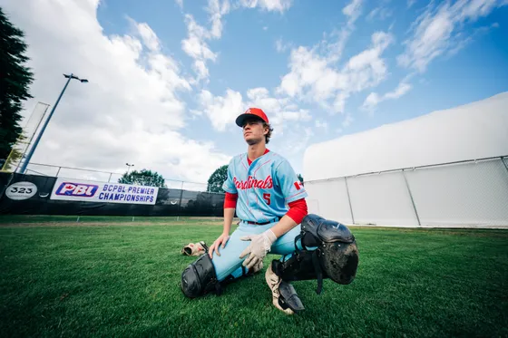 An Abbotsford Cardinals catcher crouched under a blue sky.