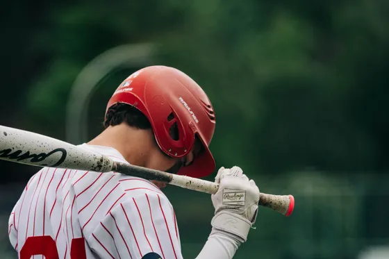 An Abbotsford Cardinals player, bat over the shoulder, against a dark ground.